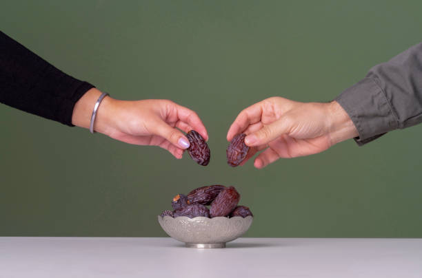 Ramadan concept, Date fruit in traditional silver bowl over green background
