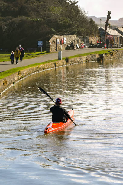Bude, Cornwall, UK - 22 February 2025: Person in a kayak at the end of the Bude Canal, which is separated from the sea by a lock gate.