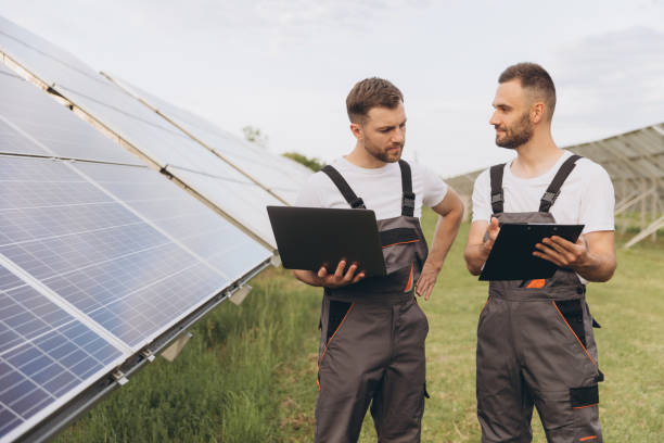 istock Energy specialist using digital tablet reading information to check the efficiency of solar panel construction. Green energy jobs. Technology. Two solar power plant workers are recording data 2202060916