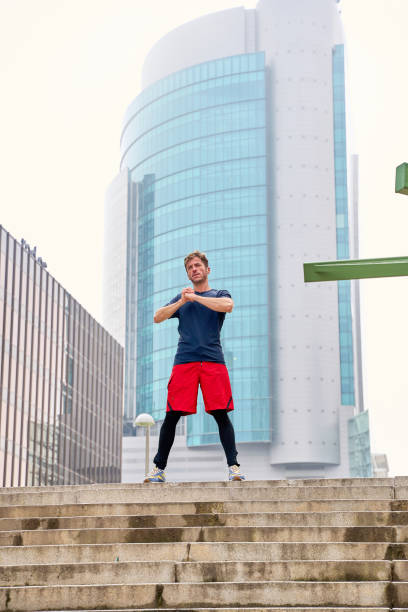 istock Sportsman stretching arms before training in urban environment 2202061666