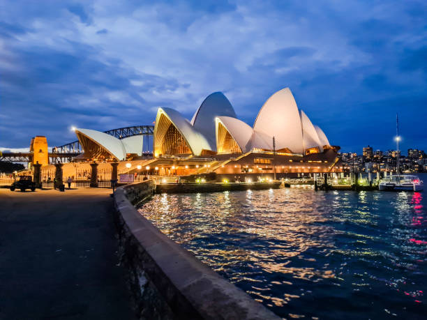 The Sydney Opera House at dawn on Australia Day, with the sails being illuminated with a display. A patrol boat of Maritime NSW stands guard at the entry to Sydney Cove because the area is closed to traffic. This image was taken from Dawes Point before sunrise on 26 January 2024.