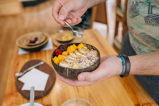 istock Unrecognizable chef adding seeds to exotic fruit and cereal breakfast bowl in cooking master class 2202068089