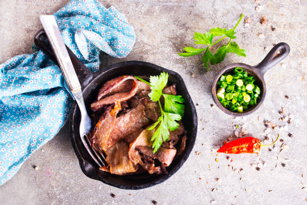 istock Grilled or pan fried pork chops on the bone with garlic and fresh greens 2202069561