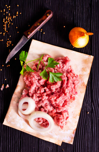 istock Fresh Raw Beef Minced Meat with salt, pepper, chilli and fresh onion 2202069604