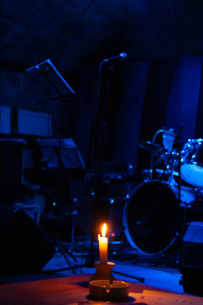 a drum set in blue light and a brightly lit candle