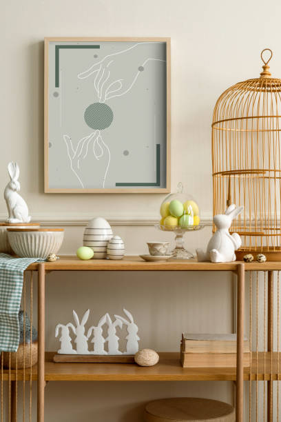 istock Cozy composition of easter living room interior with mock up poster frame, wooden sideboard, easter bunny, stylish bowl, colorful easter eggs and personal accessories. Home decor. Template. 2202072696