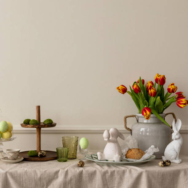 istock Creative composition of easter living room interior with copy space, vase with spring tulips, easter bunny sculpture, elegant cup, colorful easter eggs and personal accessories. Home decor. Template. 2202072885