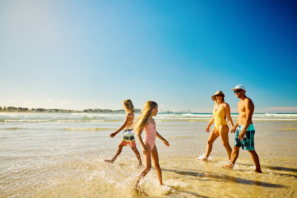 istock Family enjoying summer vacations walking and playing on the beach 2202074247