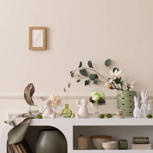 istock Interior design of easter living room interior stylish sideboard, colorful easter eggs, easter bunny sculpture, vase with leaves, magnolia and personal accessories Home decor. Template. 2202074695