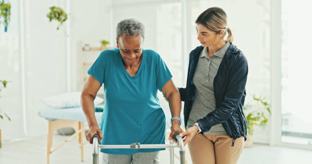 istock Senior woman, physiotherapist and walker with support, recovery and helping hand with steps at hospital. Doctor, frame and person with disability, rehabilitation or progress with balance at clinic 2202077110