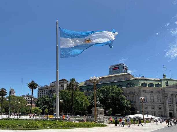 Waving proudly, the national flag of Argentina flutters against a vibrant blue sky in Buenos Aires, representing the nation's identity and deep-rooted patriotism