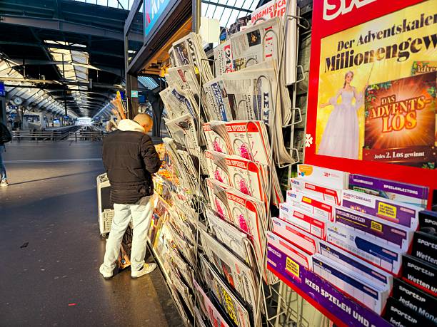 Zurich main station with kiosk and presented newspapers. The image shows the kiosk partially with some people nearby.