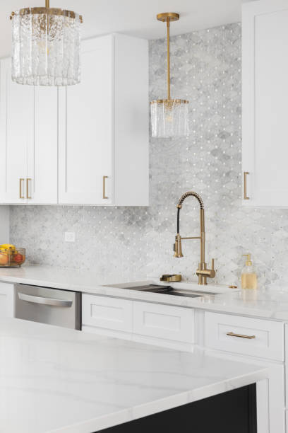 istock A gold kitchen faucet detail with white cabinets. 2202084010