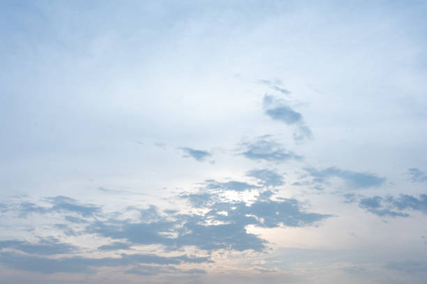 A captivating image of a serene sky at either dawn or dusk showcasing soft pastel colors and fluffy clouds The gentle light creates a peaceful and tranquil atmosphere ideal for backgrounds or design projects  The subtle variations in color and cloud formations offer a calming visual experience