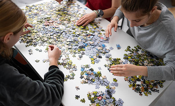 istock Girls Putting Puzzle Pieces Together On Table 2202089129
