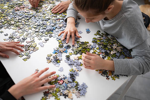istock Girls Putting Puzzle Pieces Together On Table 2202089393