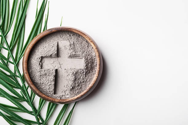 istock Bowl with ashes with cross print and palm branches on white background. Ash Wednesday 2202089591