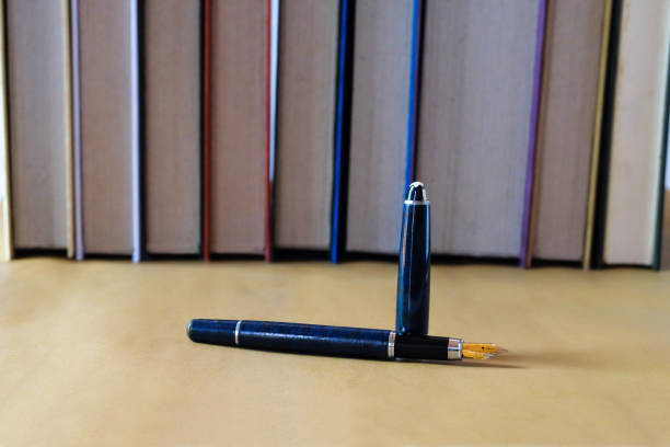 Old fountain pen on table  with books background.