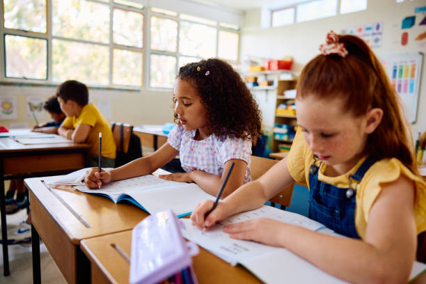 istock Two elementary school girls working in class, concentrating 2202091970