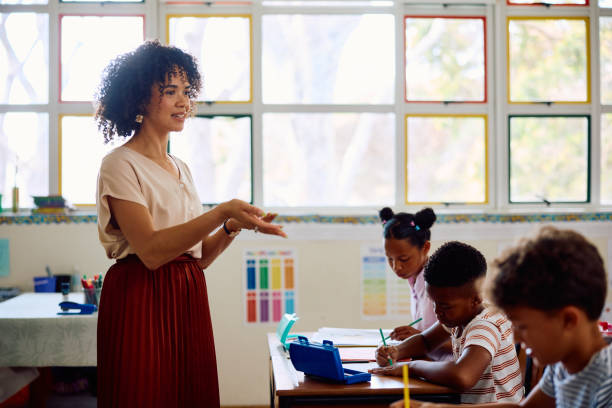 istock Elementary school teacher at front of class explaining to children 2202092230