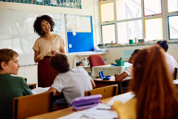 istock Elementary school teacher smiling and laughing in class with children 2202092668