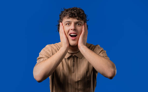 istock Shocked curly haired man glad, screaming WOW. Impressed guy, unbelievable 2202093036