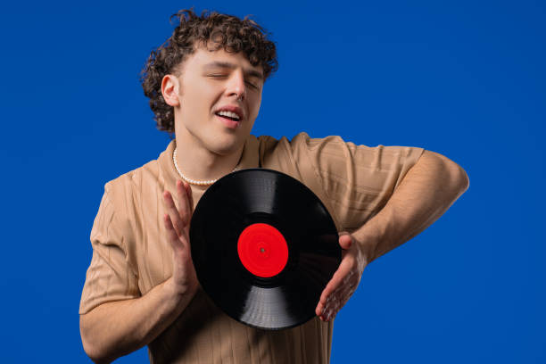 istock Handsome Man Dancing Vinyl Record Disc On blue. Hobby, Music Lover, Collection 2202093056