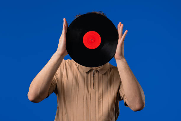 istock Young Man Hiding Head, Vinyl Record Disc On blue. Hobby, Music Lover, Collection 2202093064