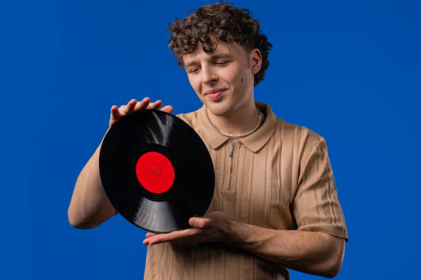 istock Handsome Man Dancing Vinyl Record Disc On blue. Hobby, Music Lover, Collection 2202093097