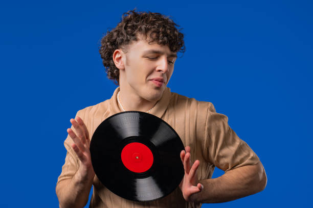 istock Handsome Man Dancing Vinyl Record Disc On blue. Hobby, Music Lover, Collection 2202093517