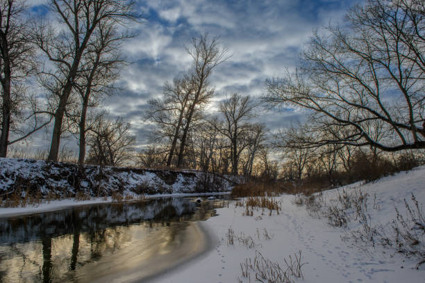 istock Snowy riverside landscape reflects winter's beauty at dusk 2202094211