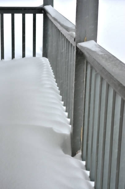 istock snow drift through a wooden porch railing 2202094834