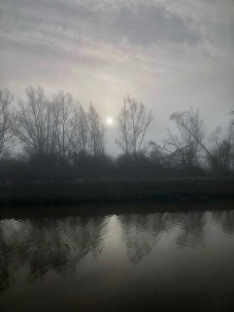 Fog and sun in autumn season on the river - Panoramic view from Vacchelli river channel (Lombardy - Italy)
