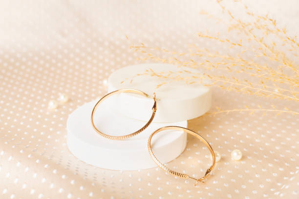 istock Golden earrings with decor on textile background 2202097910