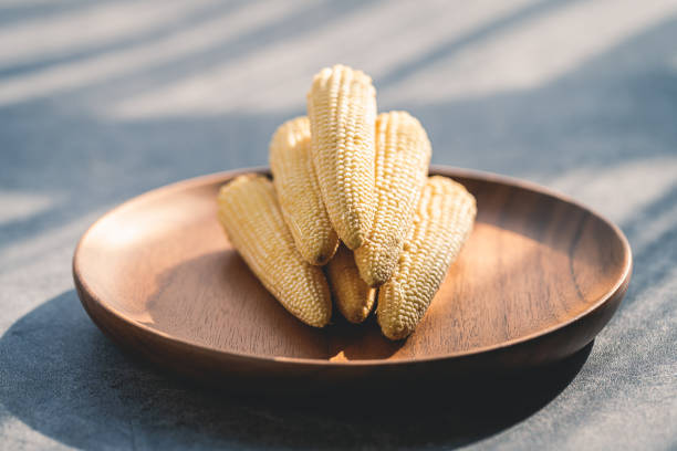 Baby corn on a wooden plate macrophotography
