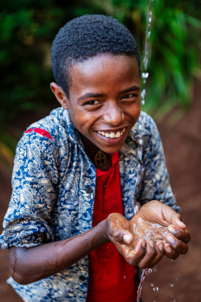 istock African young boy drinking fresh water, East Africa 2202103859