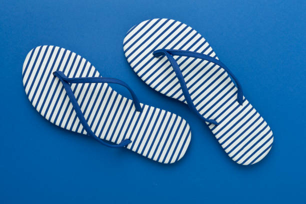 istock Striped blue flip-flops on color background, top view 2202105929