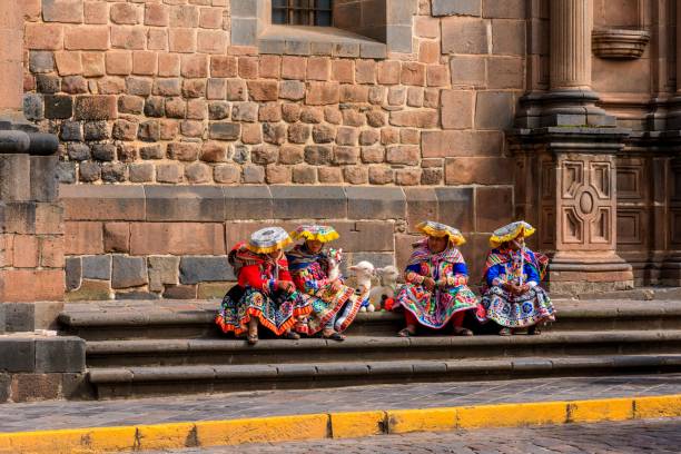Cusco, Peru – March 12, 2020: Quechua women in traditional attire with llamas at Qorikancha, Cusco