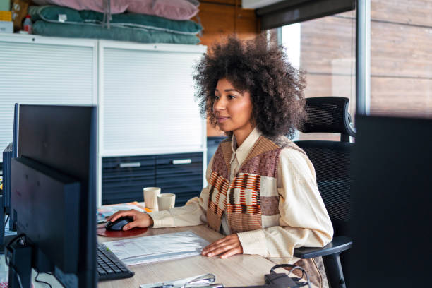 istock Young businesswoman working on computer at her desk in a modern office 2202106796