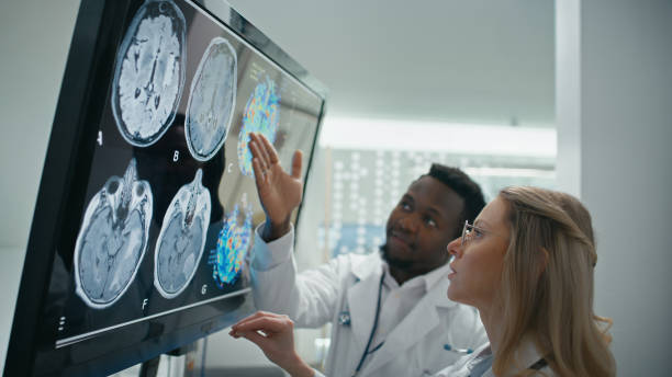 istock Doctors review patient's skull x-ray, analyze each section closely, comparing it against normal patterns to identify any potential problems 2202107306