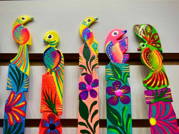 A row of vibrant hand-painted wooden birds with intricate floral designs, showcasing traditional Mexican craftsmanship.