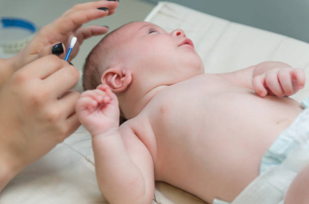 istock Mother cleaning baby's ear with cotton swab 2202111406