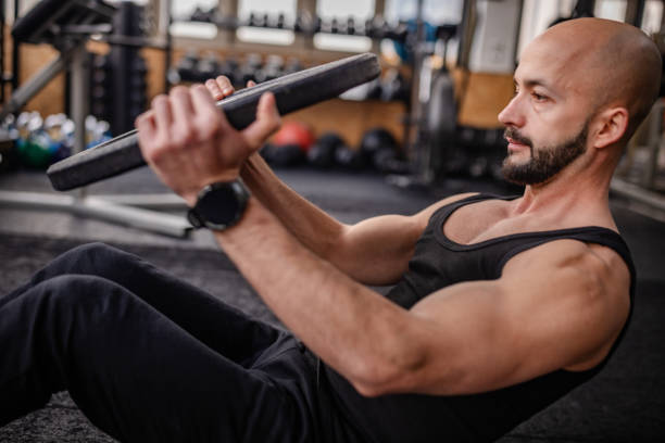 istock Engaged Man Performing Weighted Exercise in Gym 2202111579