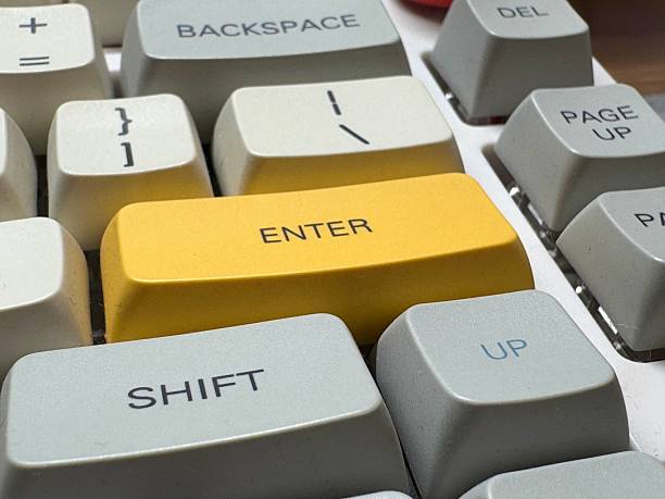 istock White mechanical keyboard in the office of a programmer employee with big yellow Enter button 2202112136