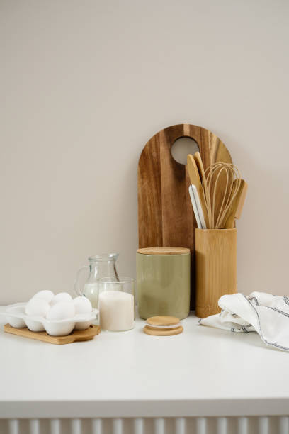 istock A curated collection of kitchen utensils and fresh ingredients: eggs, milk, sugar, cutboard, napkin is elegantly displayed on a neutral white table. 2202115310