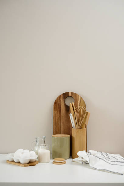 istock A curated collection of kitchen utensils and fresh ingredients: eggs, milk, sugar, cutboard, napkin is elegantly displayed on a neutral white table. 2202116094