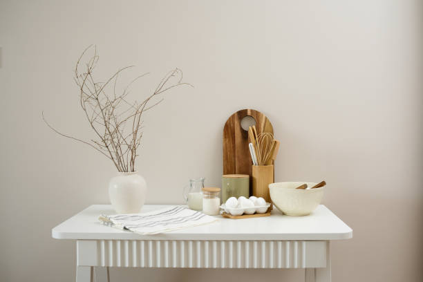 istock A curated collection of kitchen utensils, vase with dry branches and fresh ingredients: eggs, milk, sugar, cutboard, napkin is elegantly displayed on a neutral white table. 2202116358