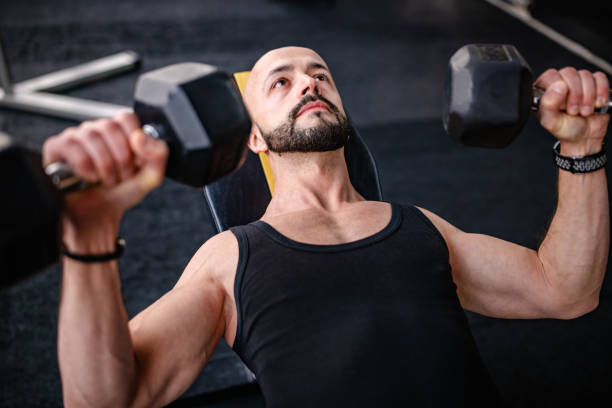 istock Focused Man Lifting Dumbbells in the Gym Workout 2202116385