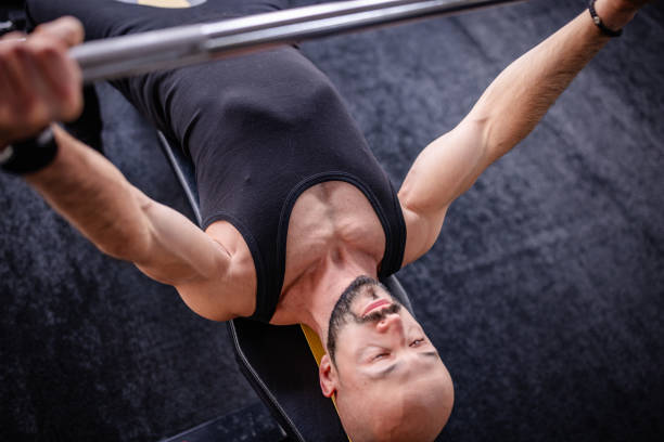 istock Focused man lifting weights in a modern gym space 2202116470