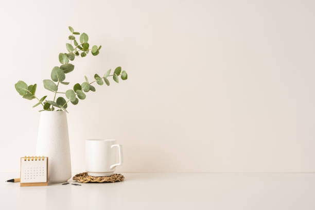 istock A modern and clean workspace featuring eucalyptus in a white vase, a coffee mug, and a small wooden calendar. Ideal for promoting minimalism, productivity, and a calm environment 2202118153